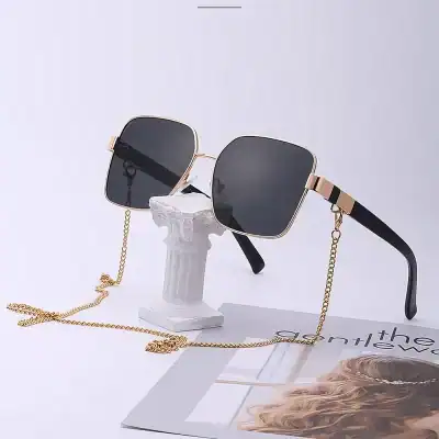 Stylish square-shaped sunglasses with black tinted lenses, gold frame, and matching chain, perfect for luxury fashion statements and sun protection.