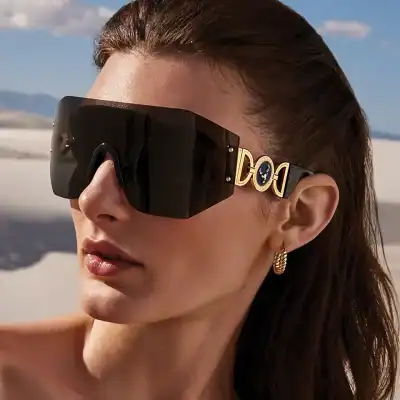 Glamorous oversized designer sunglasses with black lenses and gold accents, perfect for sun protection and fashion statements.