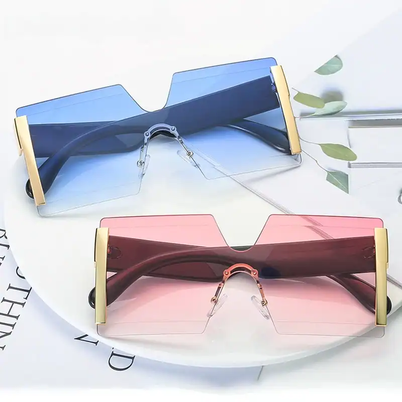 Stylish oversized fashion sunglasses with tinted lenses in blue and pink, featuring gold accents for a trendy look perfect for summer and outdoor activities.