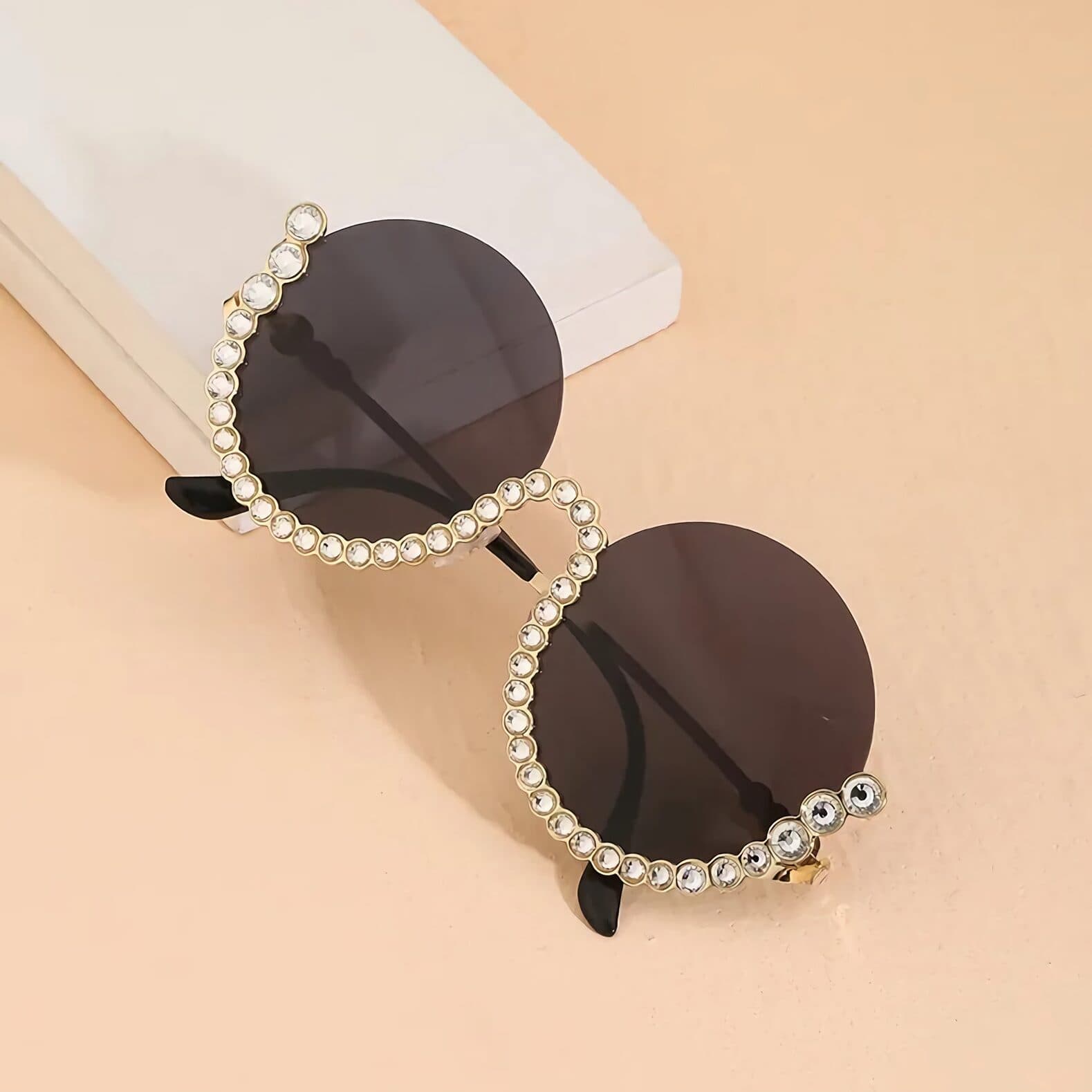 Fashionable designer sunglasses with rhinestone accents, perfect for summer accessories and eye protection.