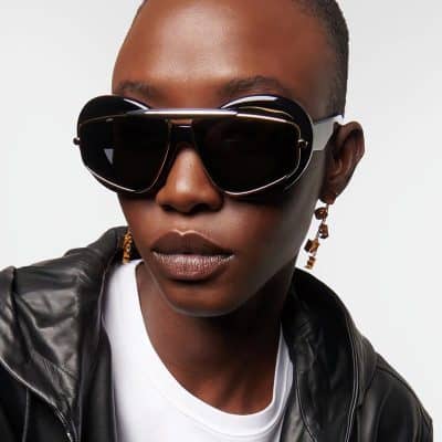 Close-up of a woman wearing trendy black sunglasses, showcasing fashionable eyewear with a sleek design perfect for stylish outfits and sun protection.