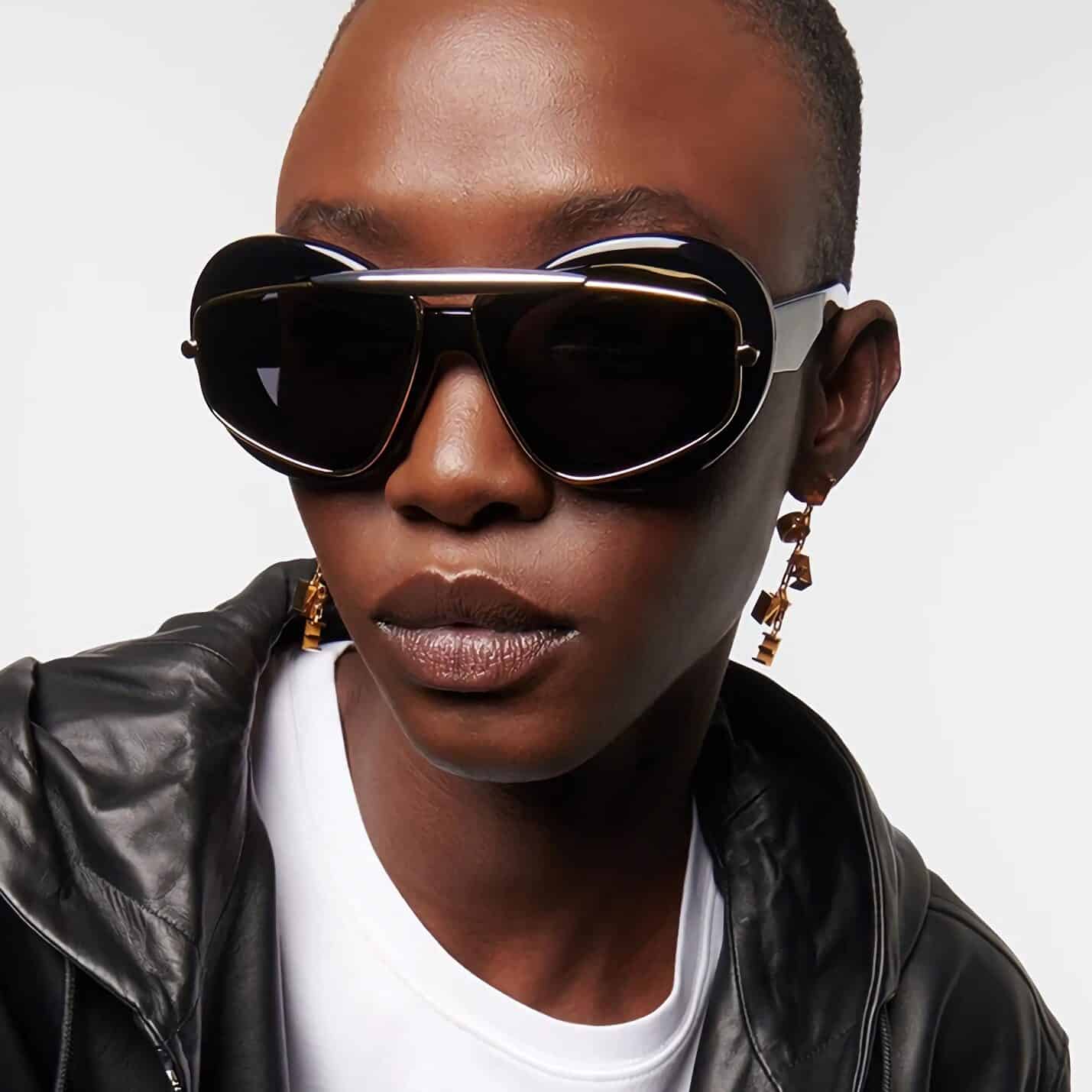 Close-up of a woman wearing trendy black sunglasses, showcasing fashionable eyewear with a sleek design perfect for stylish outfits and sun protection.