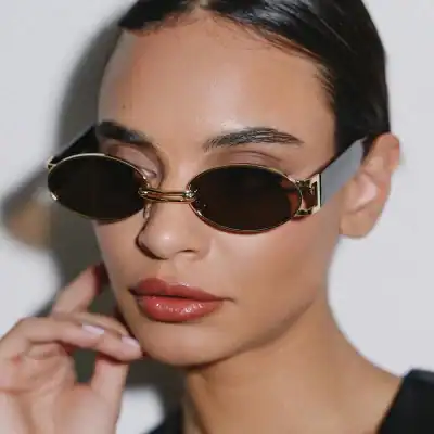 Close-up of a fashionable woman wearing trendy black sunglasses with gold accents, showcasing luxury eyewear from Monalisa Store. Perfect for fashion-forward style and eye protection.