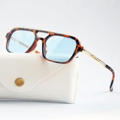 Tortoise shell sunglasses with blue tinted lenses, featuring a fashionable yet functional design for optical and sun protection. Perfect for enhancing your style and vision.
