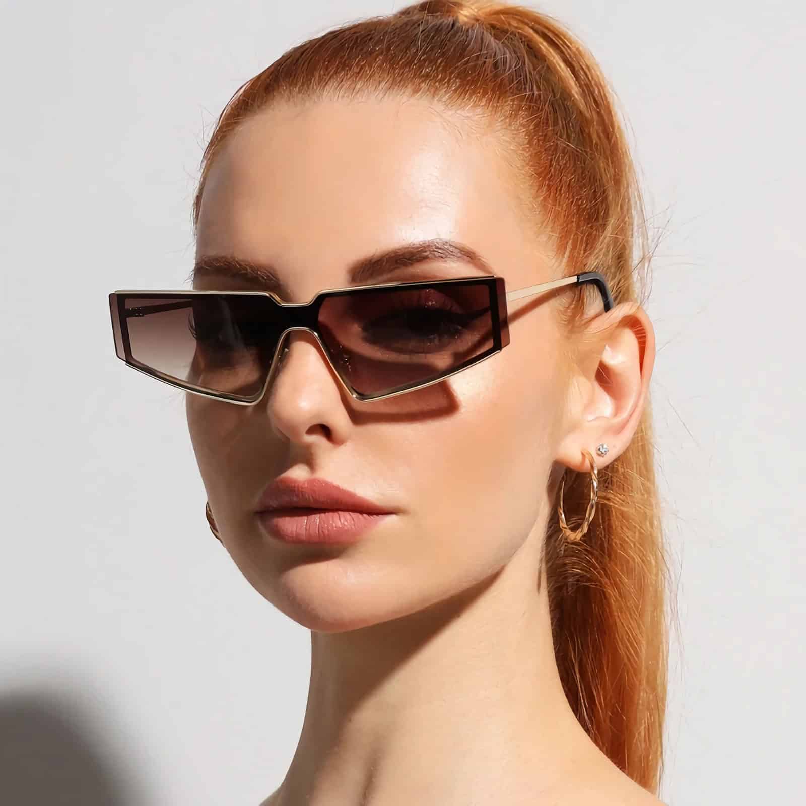 Fashionable women's sunglasses with unique shape and dark lenses, perfect for UV protection and trendy look.