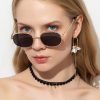 High-quality designer sunglasses with a black tinted lens and gold frame for a trendy summer look. Perfect for sun protection and fashion statement.