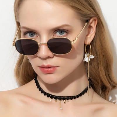 High-quality designer sunglasses with a black tinted lens and gold frame for a trendy summer look. Perfect for sun protection and fashion statement.