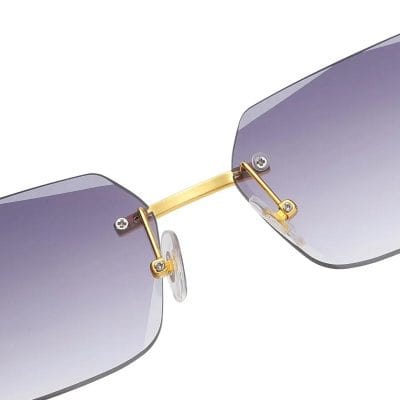 Close-up of sunglasses featuring gradient purple lenses, gold nose bridge and hinges, with adjustable nose pads for a comfortable fit.