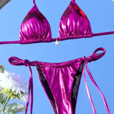 Bright pink metallic bikini with adjustable side ties, perfect for summer beachwear and swimwear fashion. Stylish and comfortable, ideal for pool parties and tropical vacations.