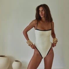 A stylish cream-colored women's swimsuit with black trim, featuring a flattering fit, perfect for beach or poolside wear, showcasing the latest swimwear trends at Monalisa Store.