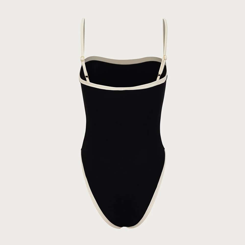 Stylish black and white one-piece swimsuit ideal for swimming and beach wear. Comfortable fit with adjustable shoulder straps and elegant design. Perfect for summer ocean adventures or poolside lounging.