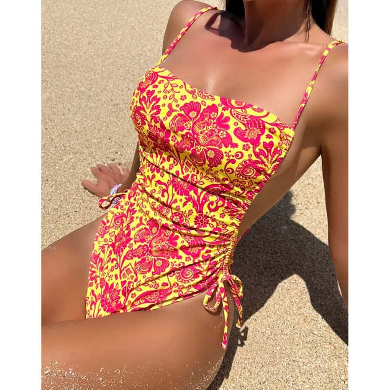 Bright pink and yellow floral beach dress with adjustable spaghetti straps, perfect for summer vacations and seaside lounging. Comfortable, stylish, and ideal for beachwear.