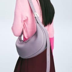 Elegant purple handbag for women with eye care accessories. Stylish and functional for everyday use, perfect for carrying sunglasses and glasses cases.