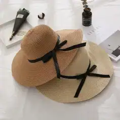 Elegant wide-brim straw sun hat with black ribbon details, ideal for outdoor fashion and sun protection, perfect for warm weather wardrobes.