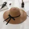 Elegant straw sun hat with wide brim and black bow, perfect for summer outdoor activities and beach days, made from durable materials for sun protection.