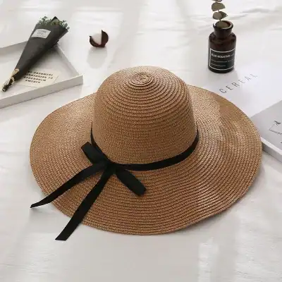 Elegant straw sun hat with wide brim and black bow, perfect for summer outdoor activities and beach days, made from durable materials for sun protection.