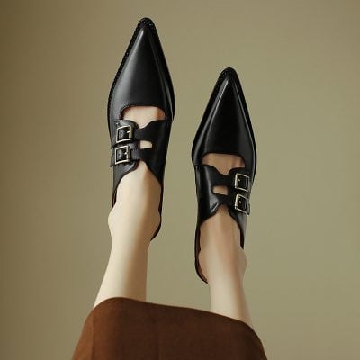 Elegant black leather shoes with double buckles, pointed toes, and stylish design. Perfect for professional and fashionable eyewear store visitors seeking trendy footwear.