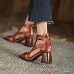 High-quality brown leather open-toe ankle heels with chunky heel and ankle strap, perfect for fashionable women.