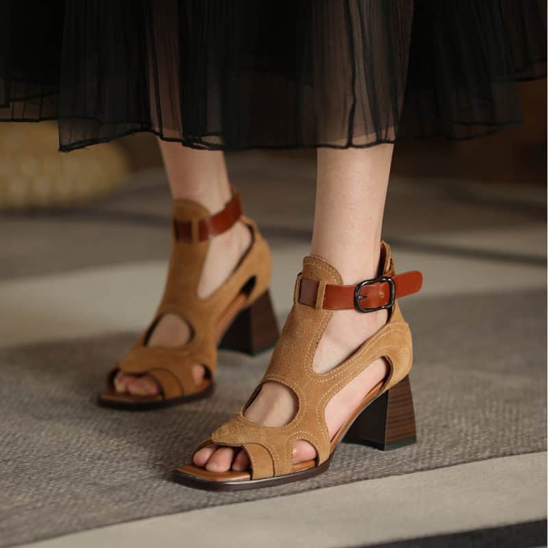 High-heeled suede sandals with cut-out design, ankle strap, and sturdy block heel emphasizing style and comfort for versatile fashion statements.