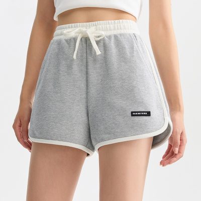 Soft grey sweatshorts with white trim and adjustable drawstring waistband, ideal for casual wear and workouts.