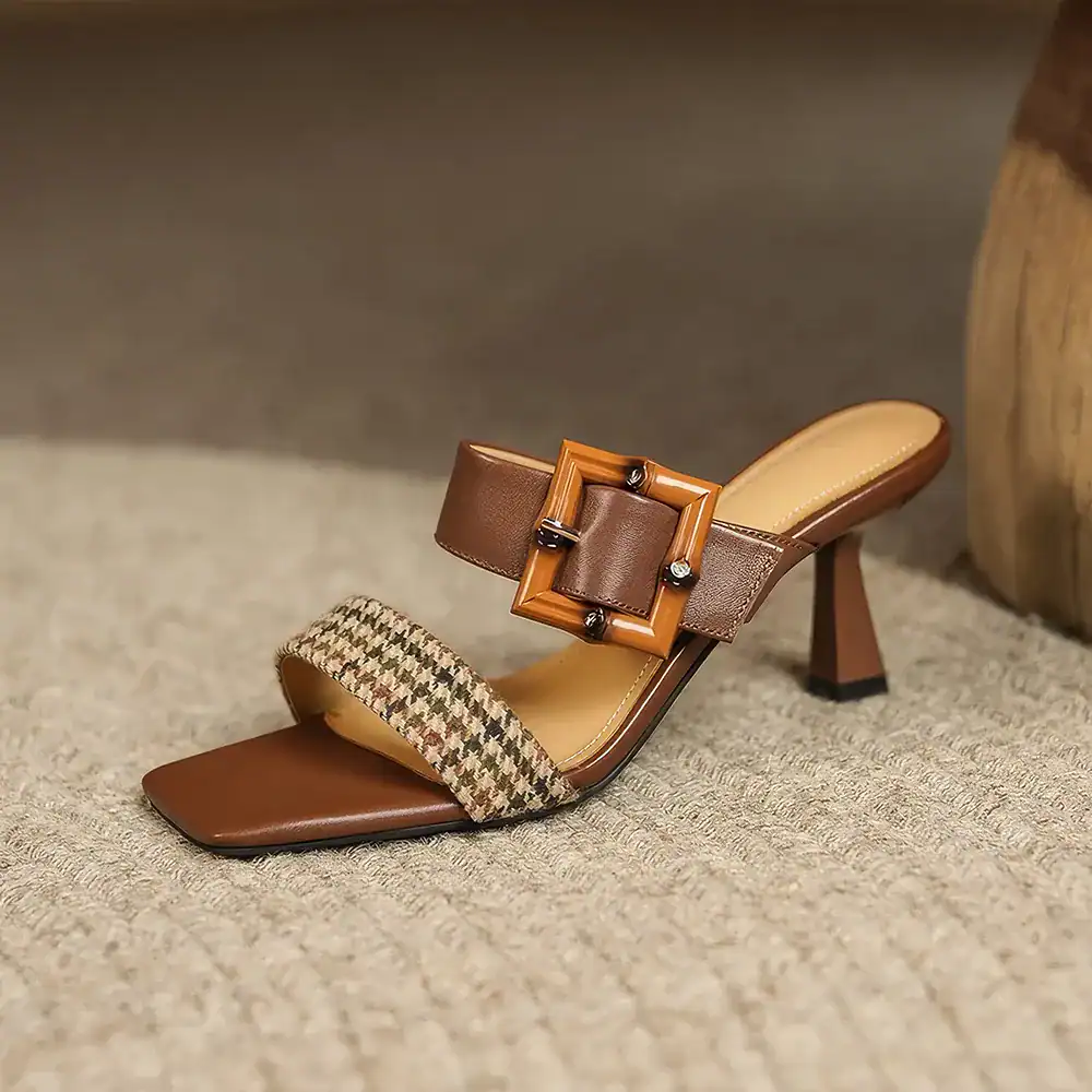 Elegant brown high-heeled sandal with a large decorative buckle, featuring a textured patterned strap and sleek design, perfect for stylish occasions.