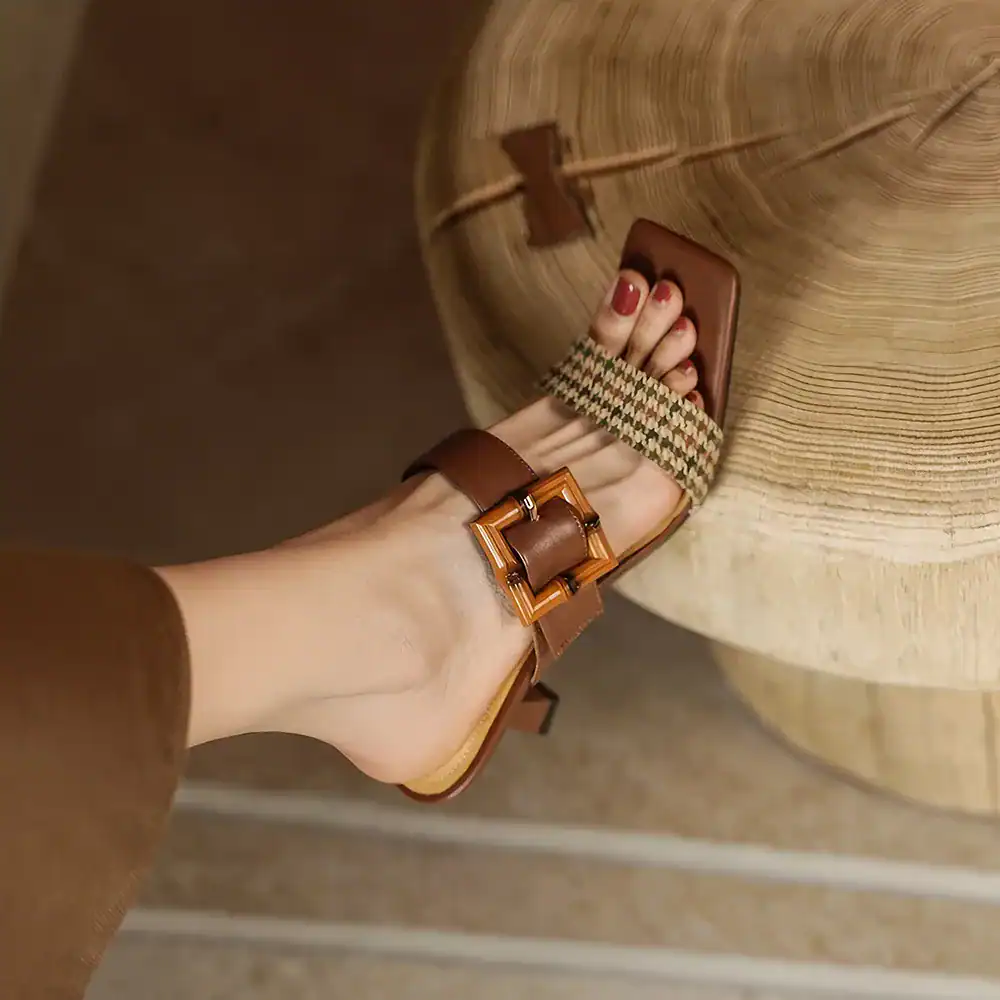 Elegant brown leather sandals featuring a decorative buckle and woven strap, perfect for comfortable daily wear and summer fashion.