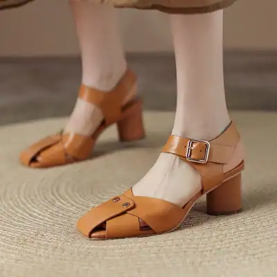 Close-up of stylish tan leather open-toe block heel shoes with ankle straps and buckle detailing, perfect for fashionable women seeking comfort and elegance.