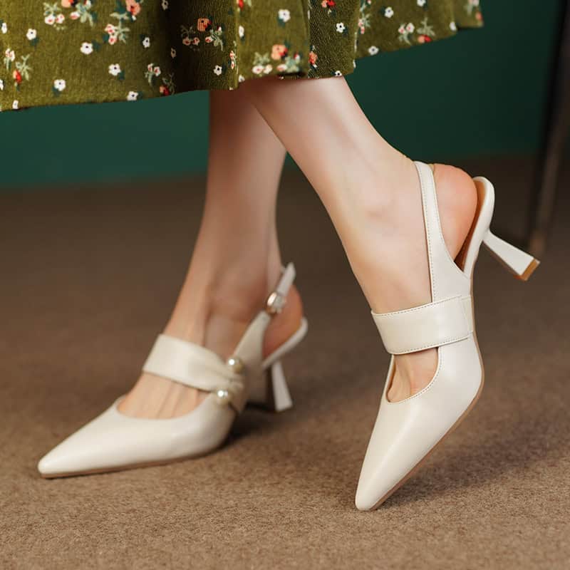 Stylish white high-heel shoes with strap, bow, and cutout design, perfect for fashion-forward women looking for comfort and sophistication.