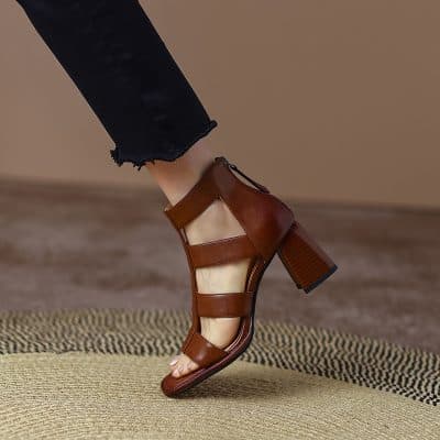 Elegant brown leather block heel sandal on a model's foot, perfect for stylish footwear and trendy accessories.