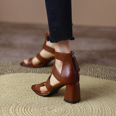 Elegant brown leather sandal with ankle strap and side zipper, perfect for fashionable women seeking comfort and style in every step.