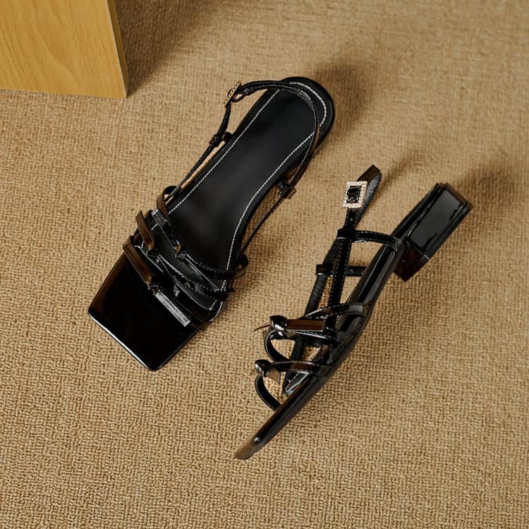 Stylish black high-heeled sandals with ankle straps and chunky heels, perfect for fashion-forward outings and special occasions.