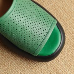 Close-up of green textured slip-on slippers with breathable perforated design, perfect for indoor comfort and relaxation.