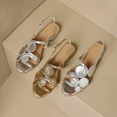 Elegant metallic women's sandals with circular embellishments, stylish design, and comfortable straps. Perfect for special occasions, parties, or fashionable outings, offering a chic touch to any outfit. Made with high-quality materials for durability and style.