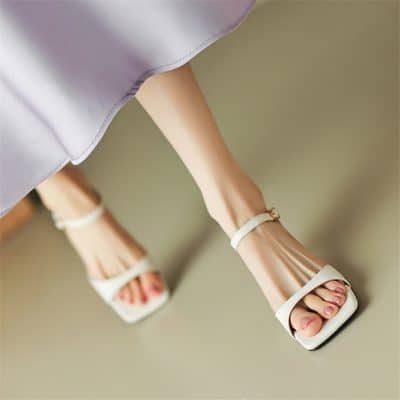 Elegant white high-heeled shoes with ankle straps, perfect for fashionable outings and special occasions.