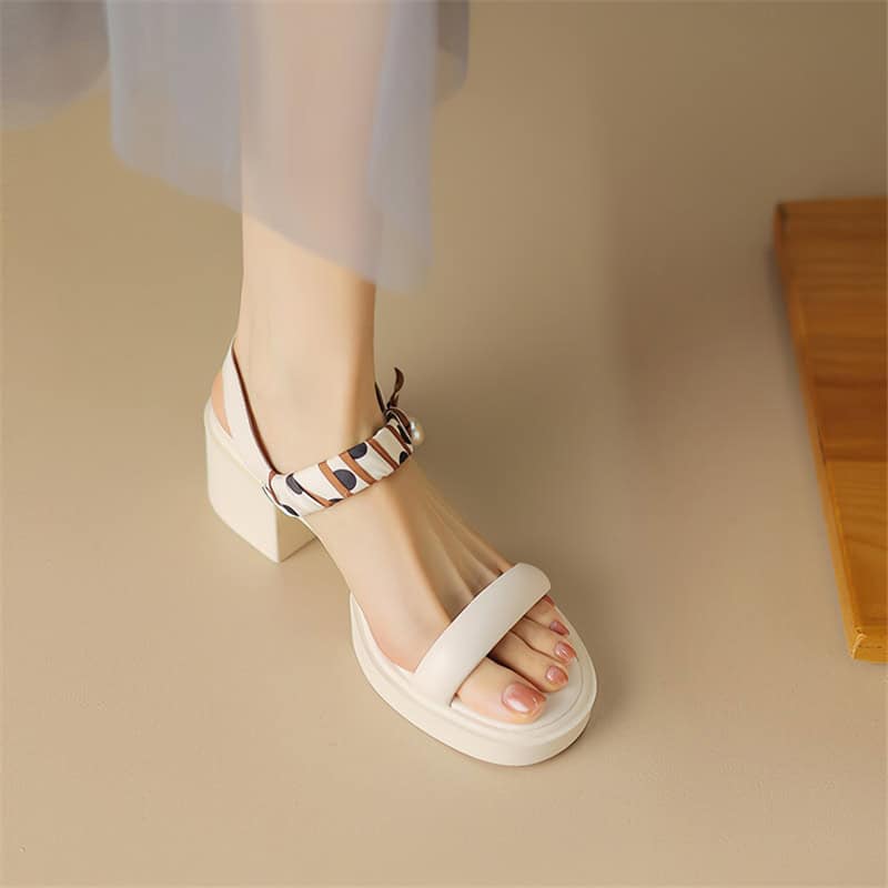Elegant white sandal with a chunky heel and colorful patterned ankle strap for stylish comfort. Perfect for modern fashion and daily wear.