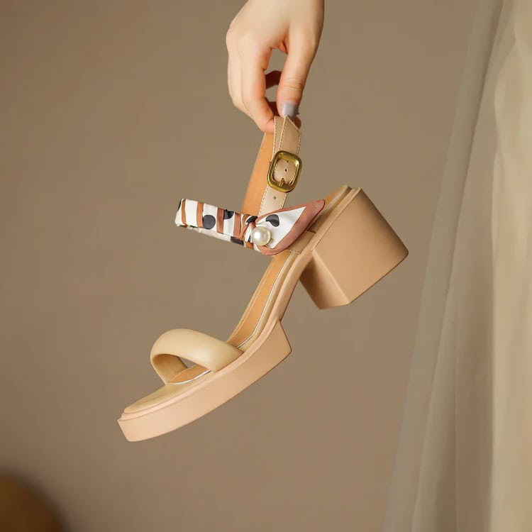 Stunning beige heeled sandal featuring a trendy ankle strap, decorative scarf detail, and block heel, ideal for stylish summer fashion and upscale occasions.