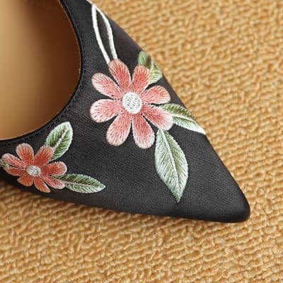 Beautiful black embroidered shoe with pink flowers and green leaves, perfect for special occasions. Premium quality, stylish design, ideal for fashion-forward women seeking comfort and elegance.