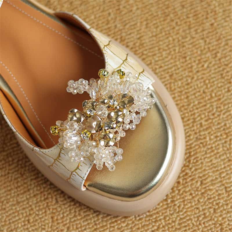 Detailed image of a stylish kids' shoe featuring a decorative pearl bow embellishment on a metallic toe cap, perfect for fashionable children's footwear.