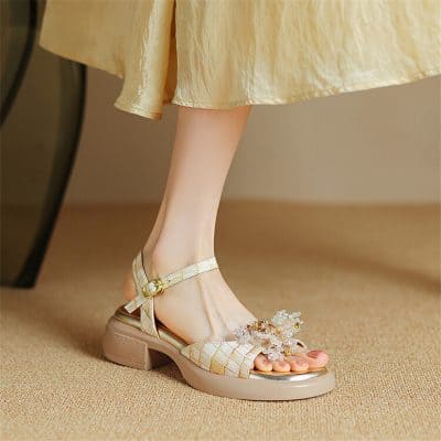 Beautiful beige strappy heeled sandal with floral jewelry adornment, perfect for special occasions and fashionable women's footwear.