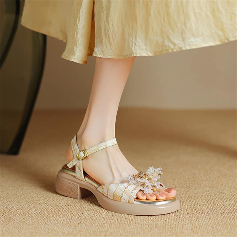 Beautiful beige strappy heeled sandal with floral jewelry adornment, perfect for special occasions and fashionable women's footwear.