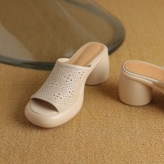 High-quality white slip-on mules with perforated design, stylish open toe, and comfortable block heel for women's fashion and footwear needs.