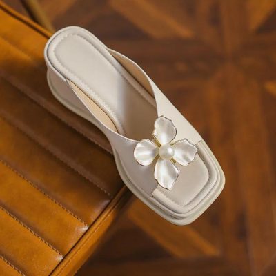 Luxurious women's white sandal featuring a floral pearl accent, ideal for fashionable events. Made with premium materials, combining style and comfort for versatile wear.