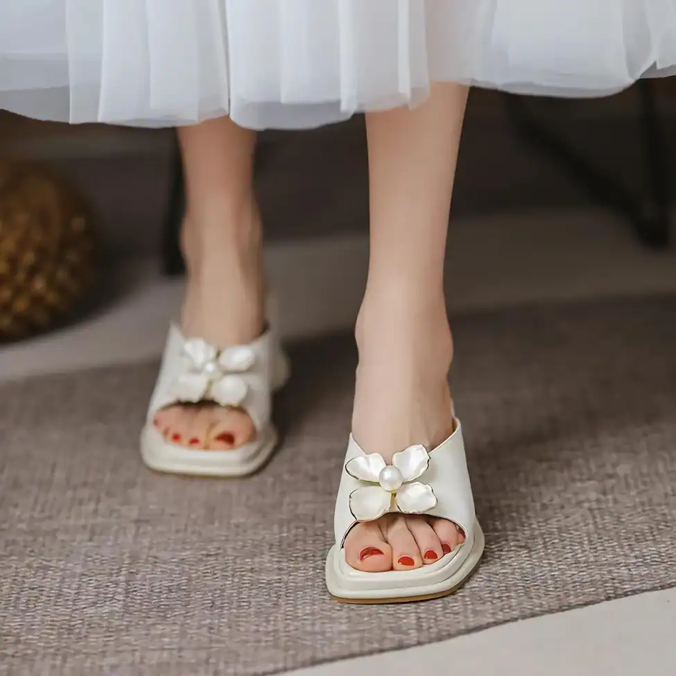 Beautiful white sandals with floral embellishments and pearls, perfect for style-conscious women.