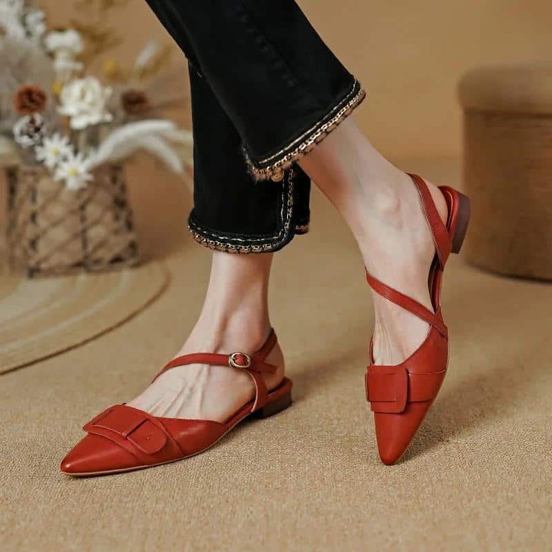 Comfortable women's fashionable red pointed-toe flats with adjustable ankle strap, perfect for stylish everyday wear or special occasions.