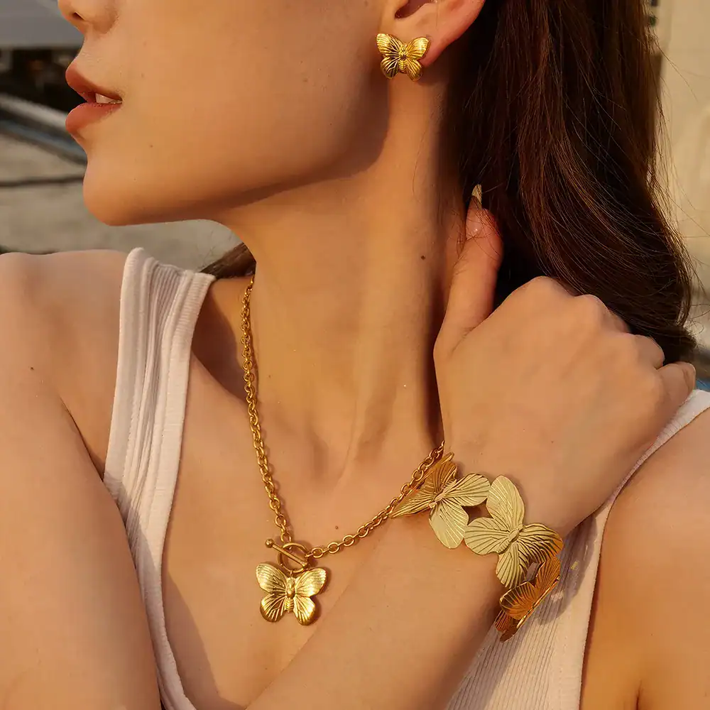 Elegant butterfly jewelry collection featuring a necklace, earrings, and bracelet in gold finish, perfect for women seeking stylish and sophisticated accessories.
