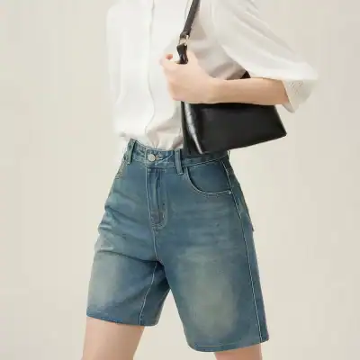 Stylish women's denim shorts paired with a white blouse and black handbag, perfect for casual outings. Visit Monalisa Store for the latest fashion trends and accessories.