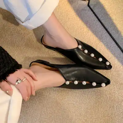 Elegant black leather shoes with pearl embellishments for women.