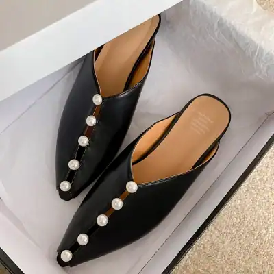 Stylish black slip-on shoes with pearl detailing, perfect for elegant and fashionable occasions. Made for comfort and chic appearance in women's footwear collection.