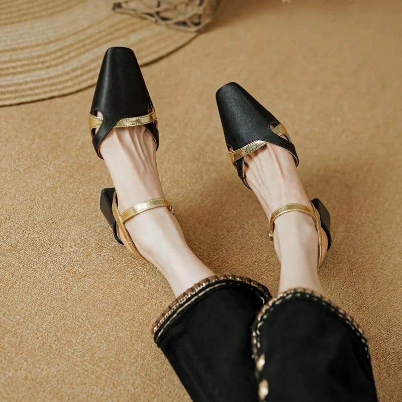 Stylish black and gold high heel shoes with ankle straps, perfect for elegant occasions, fashion statements, and formal events.
