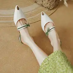 Comfortable women's beige open-toe clog shoes with ankle straps and green bow accents. Stylish footwear suitable for casual and outdoor wear.